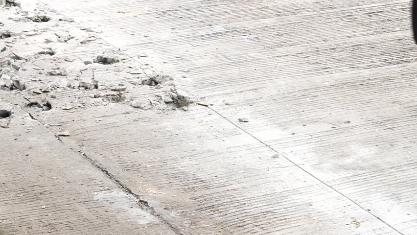 Close up of breaking concrete by hydraulic jackhammer
