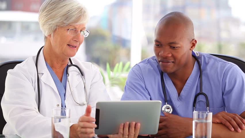 Happy doctors working with a touchscreen in their bright office