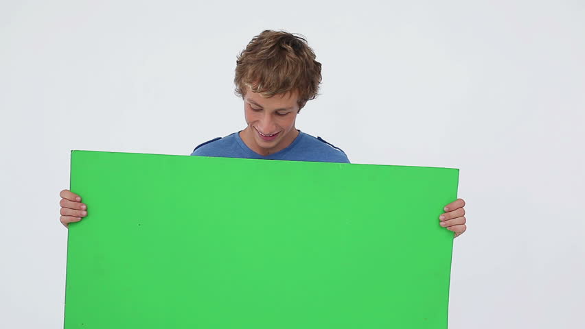 Smiling man looking down while holding a sign against a white background
