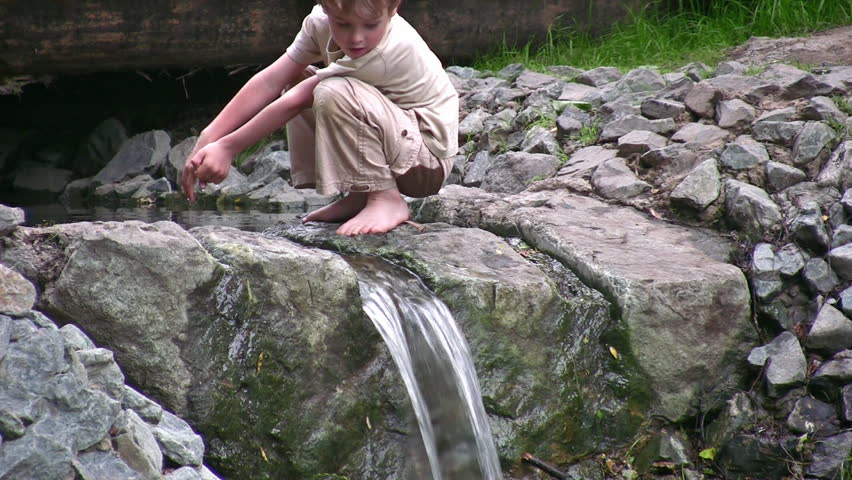 child play on small waterfall 