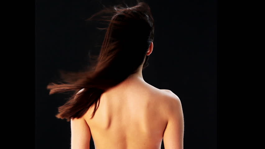 Sensual young woman with beautiful long brown hairs, posing over black background