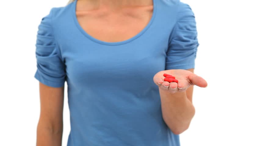 Woman holding a pill against a white background