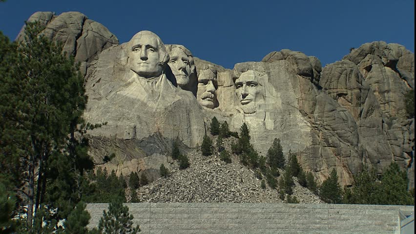 BLACK HILLS, SD - CIRCA 2004: Tilt down from Mt. Rushmore to visitors at the Memorial entrance