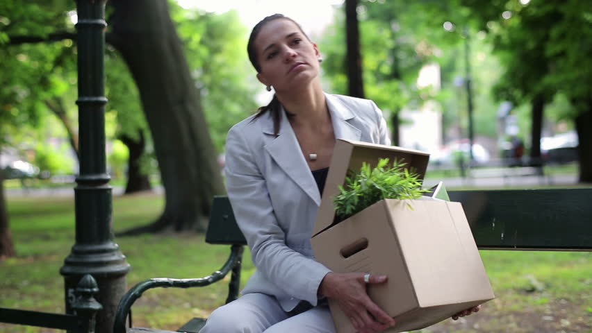 Just fired, unemployed sad young businesswoman sitting in the park
