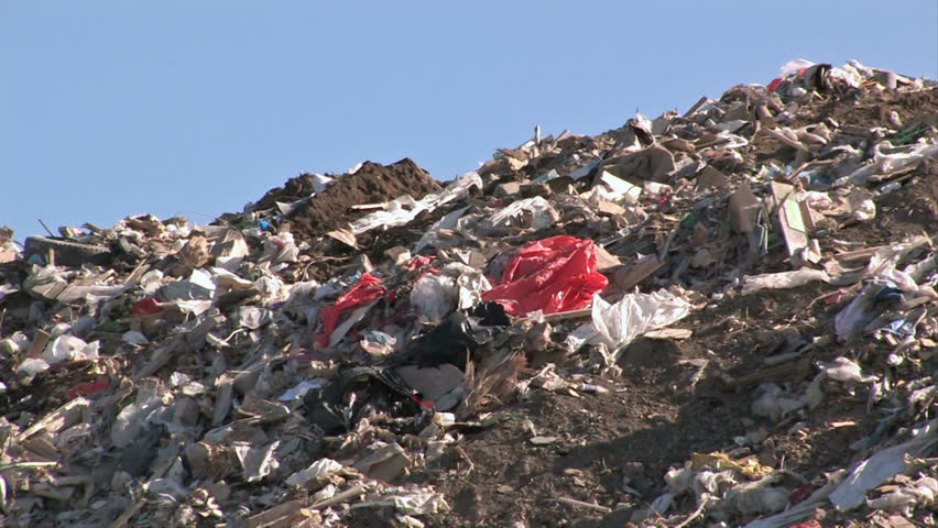 Garbage dump in Utah. Moving garbage and trash in wind.  A mountain of a landfill. Pollution and debris from business and residence household waste. Environmental waste non biodegradable.