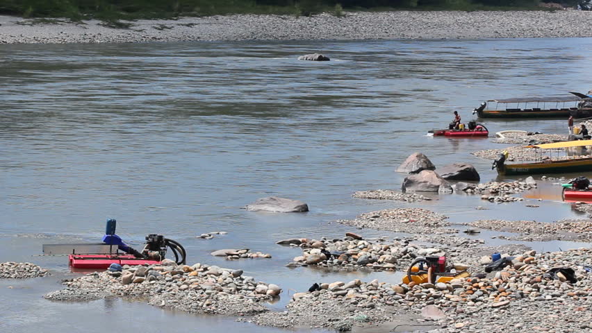 Suction dredges mining placer gold deposits. On the Rio Napo in the Ecuadorain Amazon.