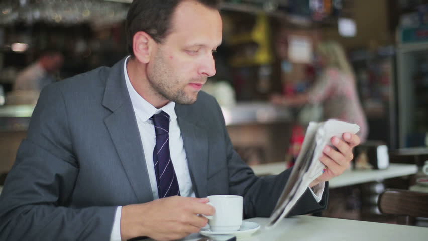 Young businessman reading bad news in newspaper
