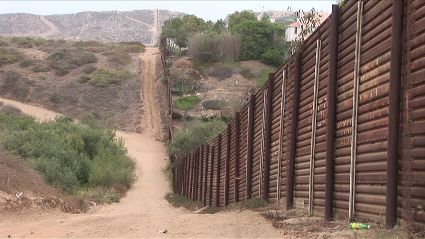 View of United States border fence going off into the distant desert in San Diego