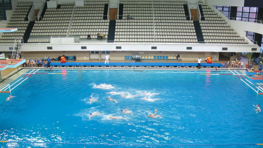 Teams play waterpolo in pool of sports complex, time lapse

