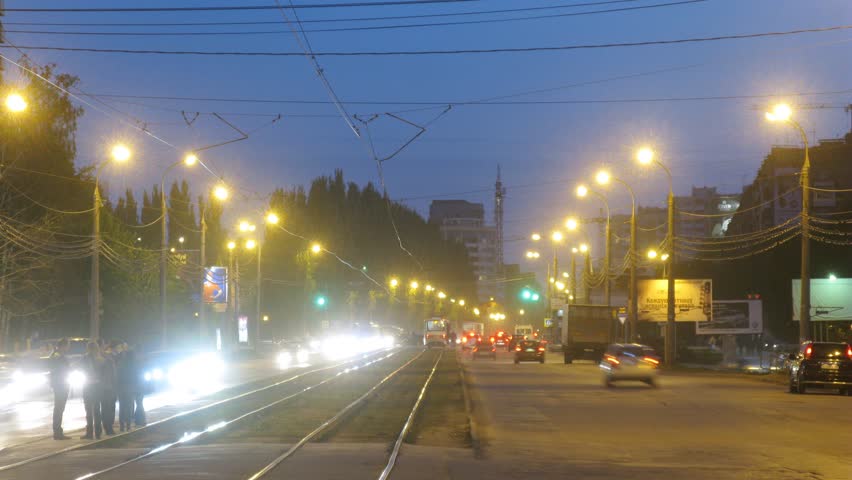 SAMARA - MAY 5: (Timelapse View) Trams go in middle of highway among stream of cars in evening, on May 5, 2012 in Samara, Russia