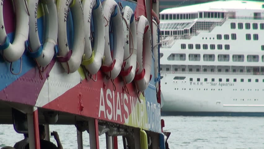 HONG KONG - JULY 28 2010: Closeup of a Star Ferry with a cruiseship in the background in Hong Kong
