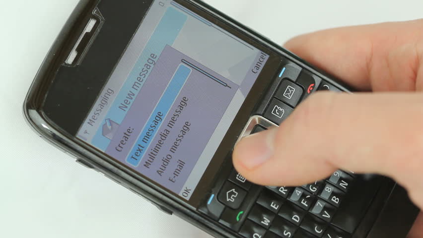 Texting a love message - Male hand typing a text message "I miss you soo much call me" on a smart phone with full qwerty keyboard