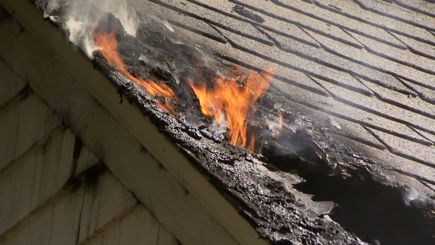 Fames coming our of roof of house on fire