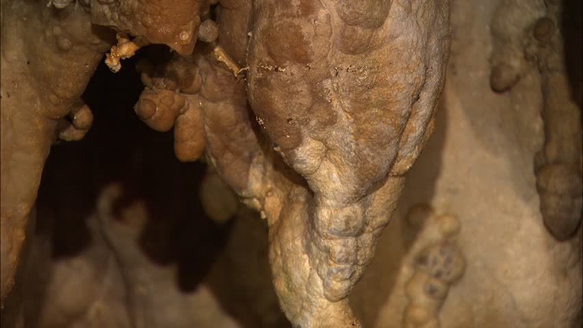Pan across nice group of stalactites in cave
