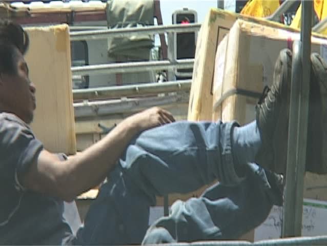 man asleep on back of lorry