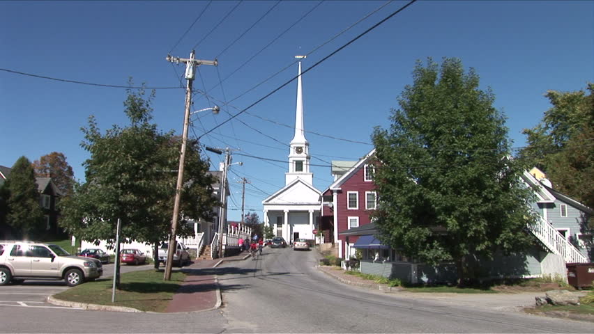 Montpelier, Vermont - CIRCA September 2007: Traffic rolls down a quiet country town during the day with a tall church in the background