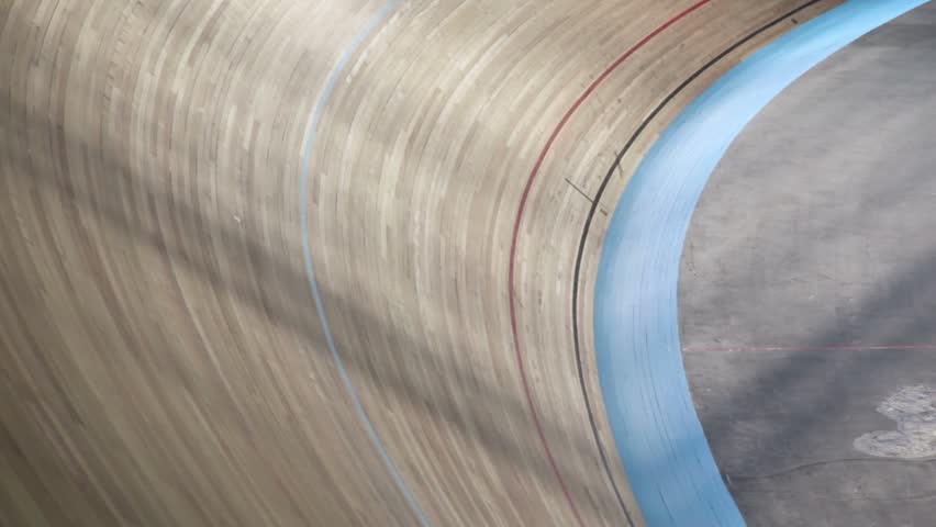 Cyclists ride by track turn during race in stadium