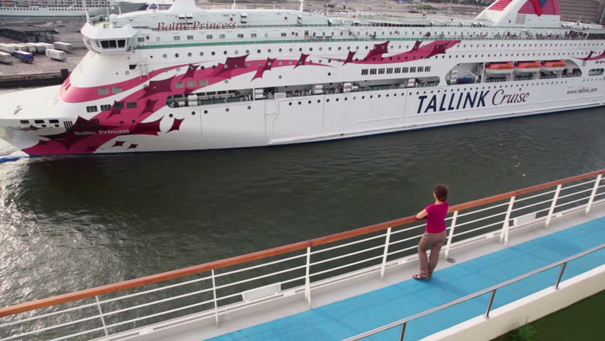 HELSINKI - JULY 20: Woman stand and watch cruiser floats away from port on July 20, 2011 in Helsinki, Finland.