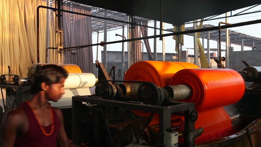 RAJASTHAN, INDIA - CIRCA MAY 2011: Newly dyed fabric being washed and rolled, Sari garment factory