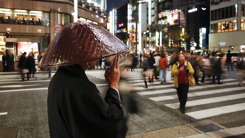 TOKYO, JAPAN - CIRCA MAY 2011: Shinto priest seeking donations (Alms) on the main shopping street from people