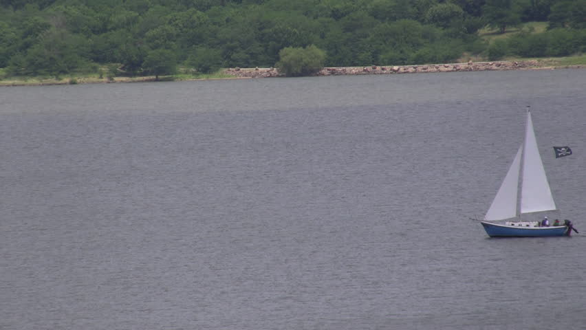 Blue sailboat on the lake flying a pirate flag. Lake Perry Reservoir, Kansas.
