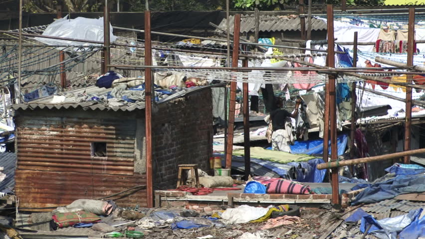 Mumbai, India - May 15, 2011: Man hanging out clothes on a line. Over 400 Million are classed as ultra poor in India. Poverty rates are higher than some East Asia countries such as Vietnam.