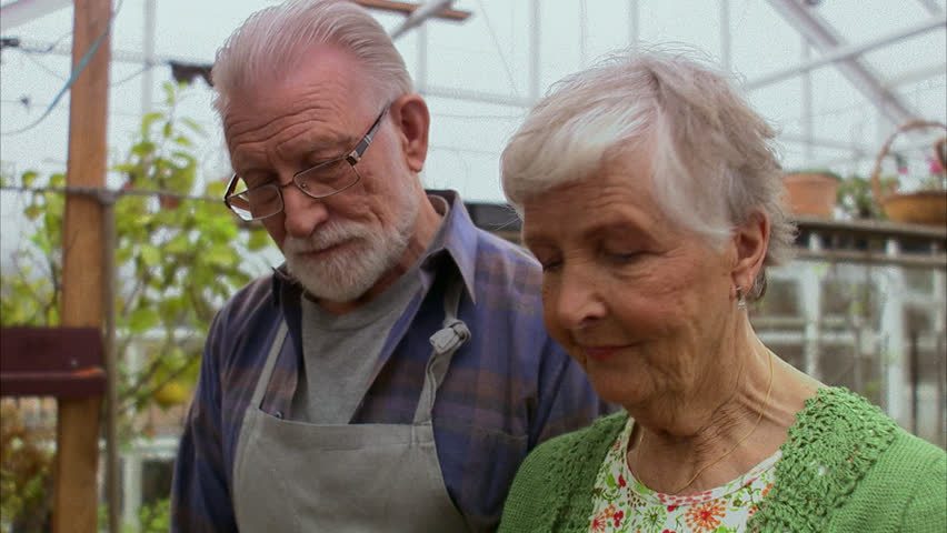 Elderly couple smelling a plant