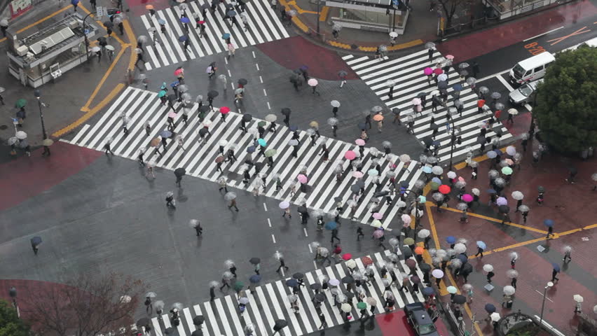 Shibuya, Shibuya Crossing, crowds of people crossing the famous crosswalks at the centre of Shibuyas fashionable shopping and entertainment district