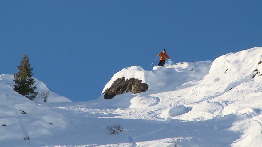 Male skier carving through steep terrain