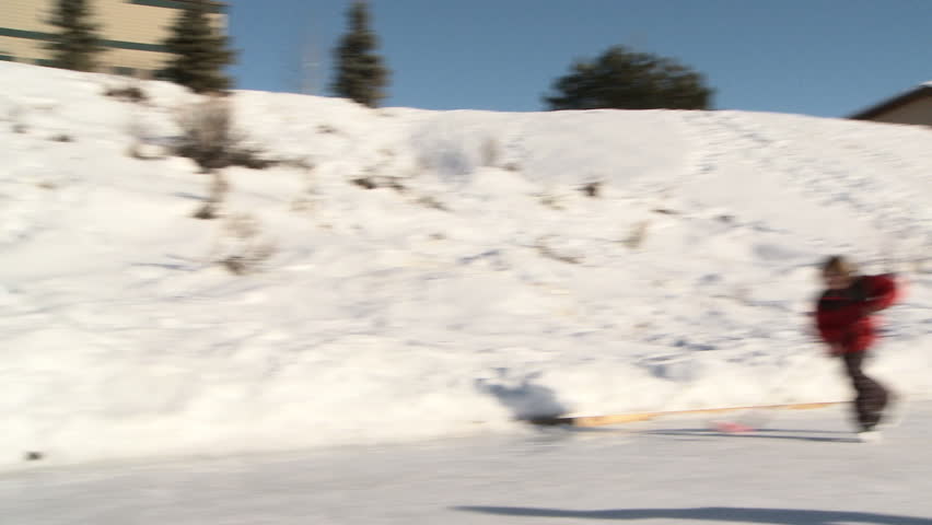Four young kids play hockey on backyard ice rink