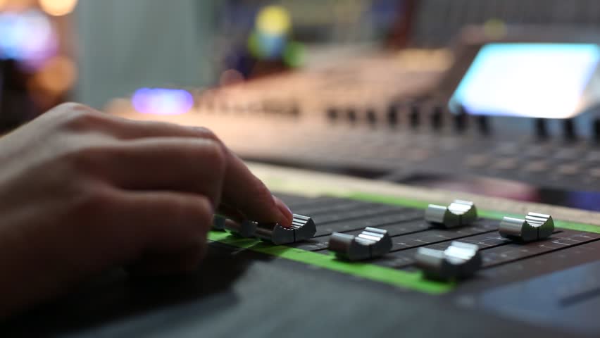 Hand on professional audio mixer. Sharp near of hand, a little  DOF.