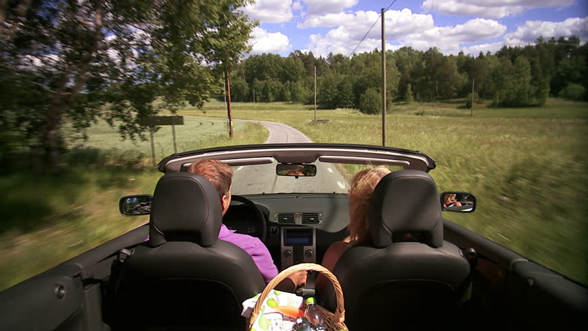 A couple in a convertible car