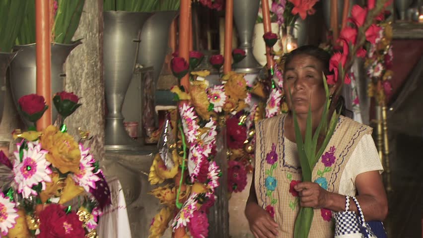 MEXICO - CIRCA 2010: A Woman Prays At An Alter Filled With Flowers