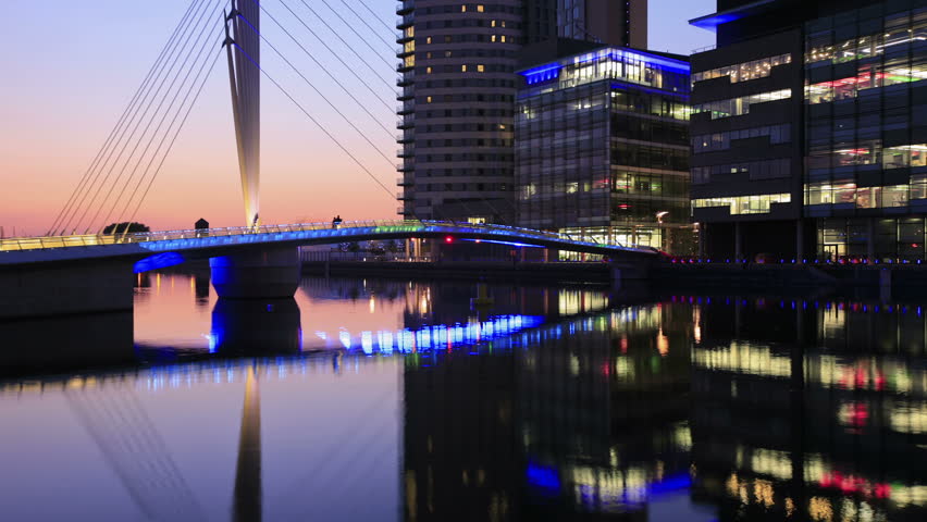 MANCHESTER, LANCASHIRE/ENGLAND - JUNE 2: Mediacity footbridge at dusk with changing colors floodlights on June 2, 2011 in Salford Quays. The swing bridge was built to serve MediaCity UK.