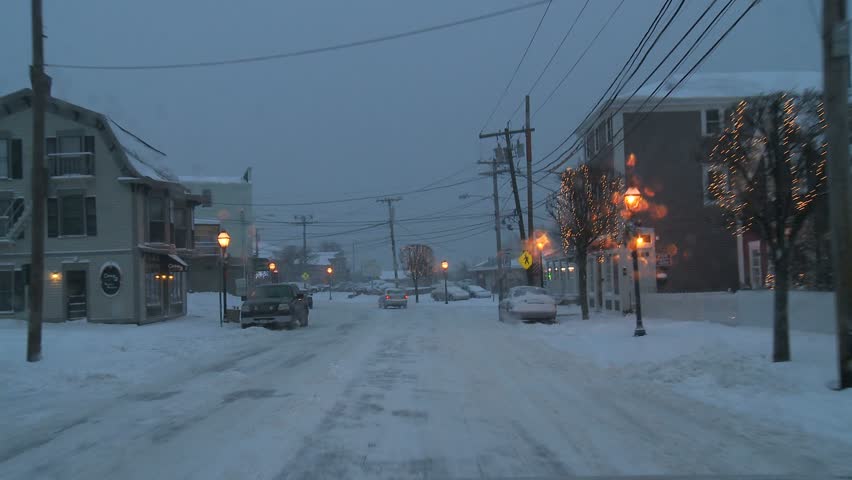NEW ENGLAND - CIRCA NOVEMBER 2009: View through windshield while driving on snowy street at dusk 