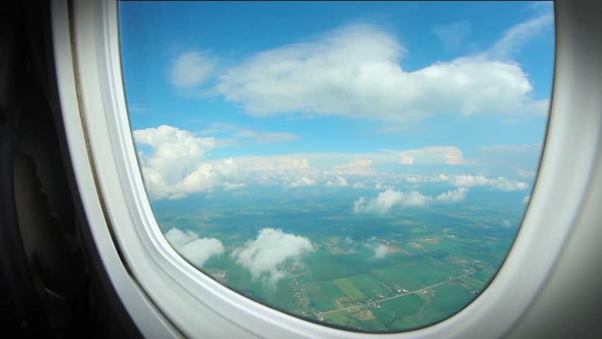 Looking out the window of an airplane as clouds pass by.