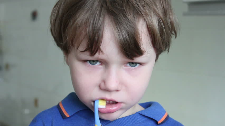 Boy brushing his teeth with a brush