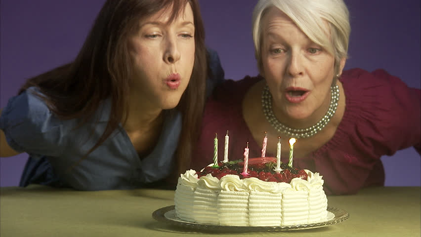 Mother and grown up daughter with a birthday cake