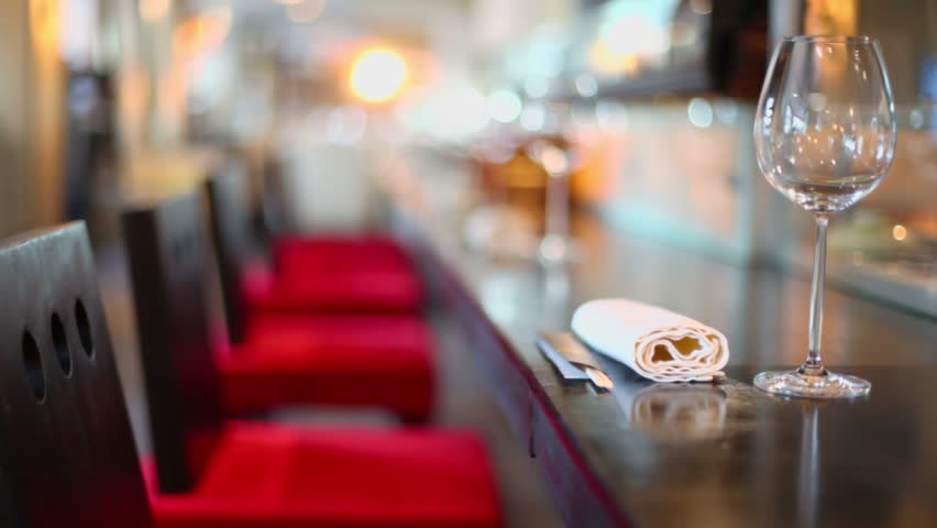 Waiter walk near long table with glasses and chopsticks at restaurant, focus changes