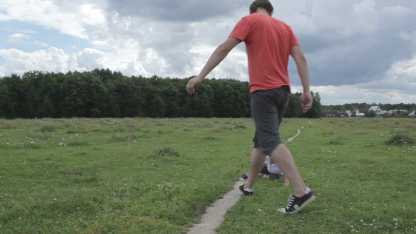 Young happy thirty year old father with his son running across the field and playing.