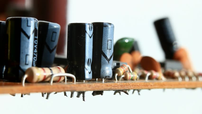 Macro of hand unsoldering and pulling out condenser from circuit board