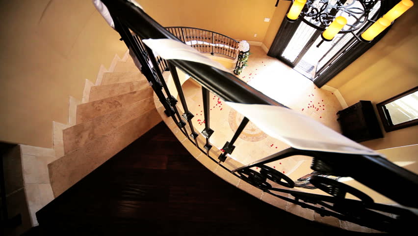 Young bride in full wedding dress veil walking out elegant entrance hall luxury house