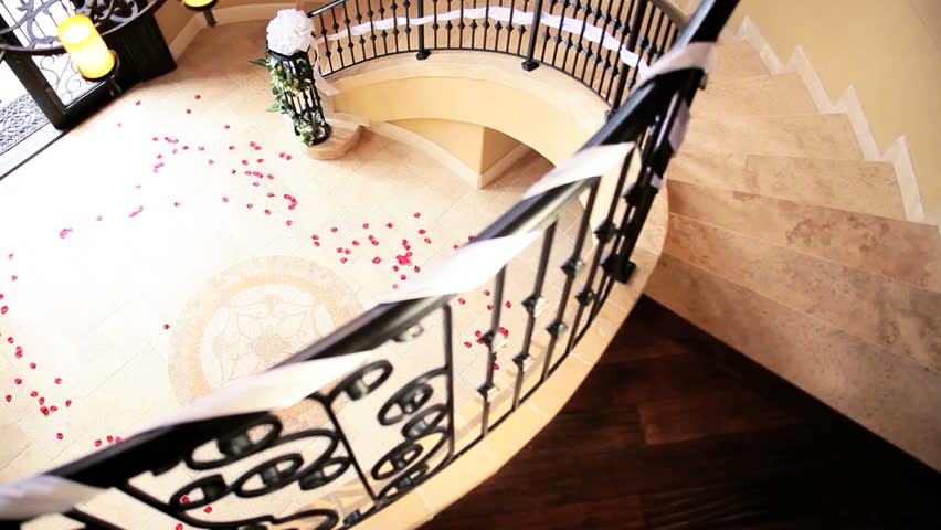 Young bride in full wedding dress veil walking through elegant entrance hall luxury house
