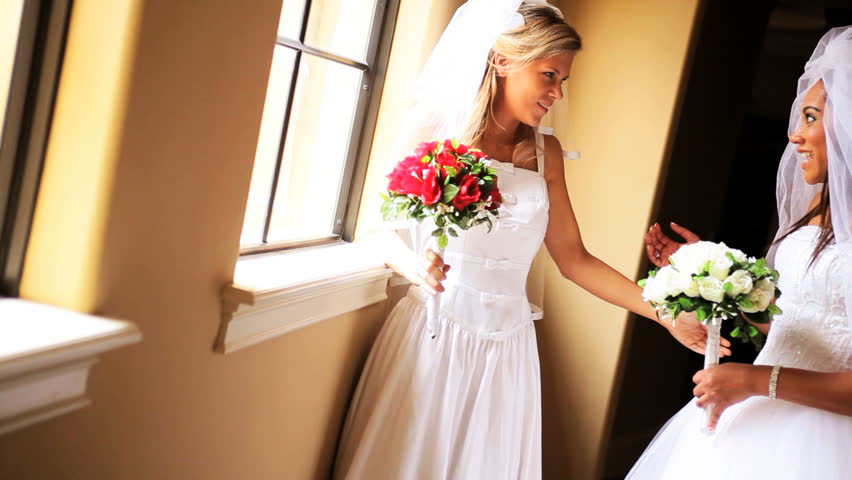 Double wedding beautiful African American Caucasian friends traditional white bridal gowns