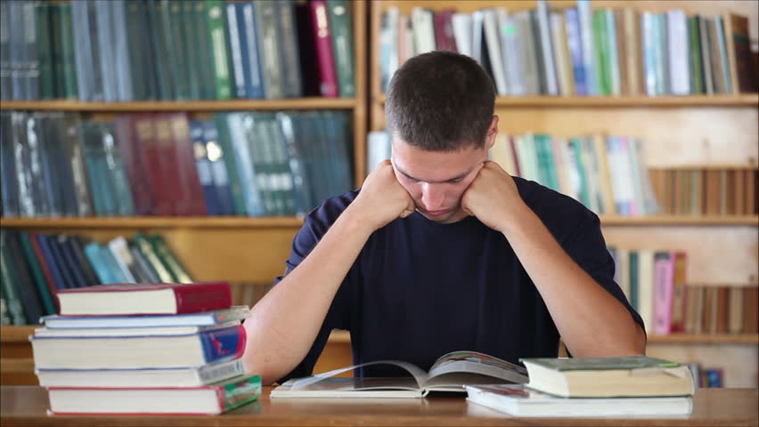 tired student in the library reading books  