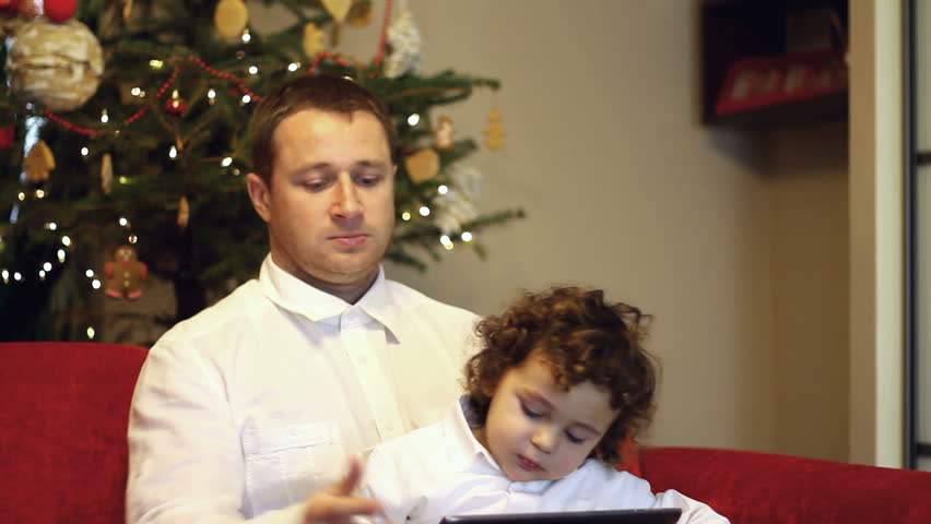 Father and his son with tablet computer pointing of something
