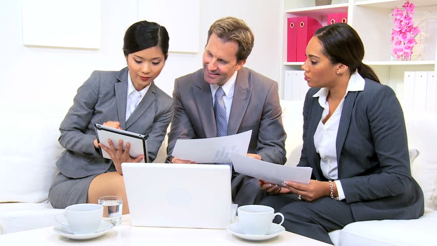 Three multi ethnic business colleagues meeting modern office
