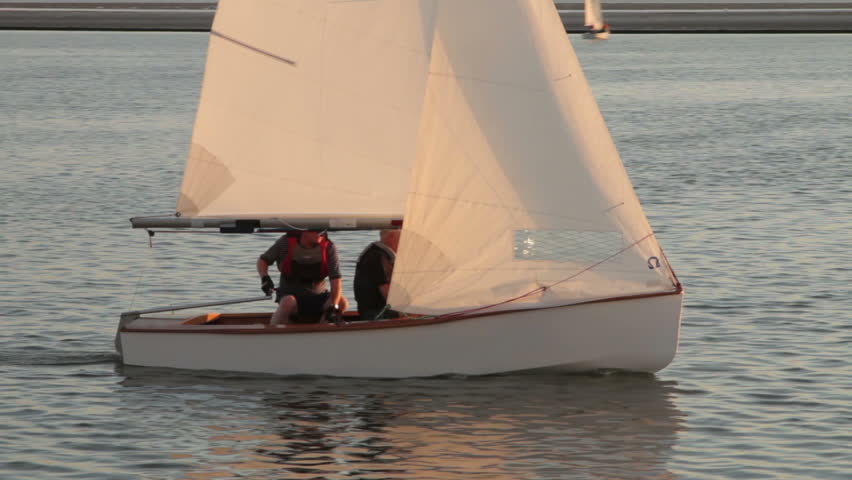 WEST KIRBY, WIRRAL/ENGLAND - AUGUST 9: Sailing boat crew sail on peaceful lake at sunset on August 9, 2012 in West Kirby. The Marine Lake is a man made coastal lake fed by the sea at high tide.  