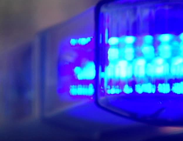 Red and blue police light bar on top of cruiser flashing at night PAL video