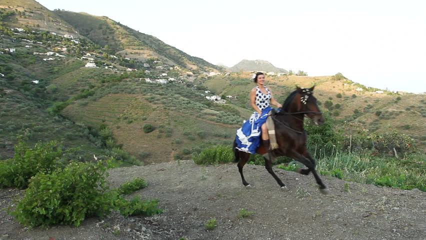 Woman riding a galloping horse in Andalusia, Spain